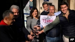 Store employees celebrate after selling the winning Christmas lottery ticket known as El Gordo, or The Fat One, in Logrono, Spain, Dec. 22, 2024.