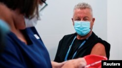 FILE - A nurse prepares a dose of a COVID-19 vaccine for a physician, classified as high-risk, in Melbourne, Australia, Feb. 22, 2021.