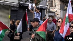 A Palestinian boy holds up a portrait of slain Hamas leader Yahya Sinwar during a rally in Ramallah in the occupied West Bank, Oct. 18, 2024.