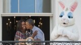 U.S. President Barack Obama kisses first lady Michelle Obama alongside the Easter Bunny during the annual White House Easter Egg Roll on the South Lawn of the White House in Washington, DC.