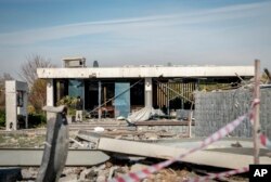 Seorang pria berdiri di depan rumah Peshraw Dizayi yang terkena serangan rudal Iran di Irbil, Irak, Selasa, 16 Januari 2024. (Foto: AP)