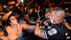 Metropolitan Police are confronted by protestors along a section of 16th Street, Northwest, renamed Black Lives Matter Plaza, Aug. 27, 2020, in Washington, after President Donald Trump had finished delivering his acceptance speech from the White House. 