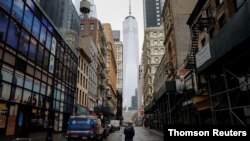 Un hombre camina en la calle Fulton que luce casi desierta en el distrito financiero del bajo Manhattan, en Nueva York.