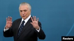 FILE - Brazil's President Michel Temer gestures during a ceremony at the Planalto Palace in Brasilia, Brazil, March 7, 2017.