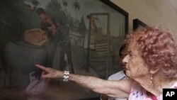 Audey Elliot of Adelaide, Australia, right, touches a painting depicting Khmer Rouge torture as she tours in the former Khmer Rouge's notorious S-21 prison now known as the Tuol Sleng genocide museum in Phnom Penh Cambodia, September 16, 2010.