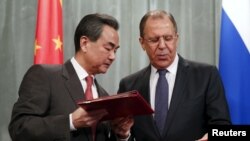 2015年4月7日俄罗斯外交部长谢尔盖·拉夫罗夫（右）在莫斯科与中国外交部部长王毅交换文件