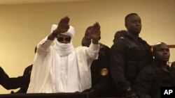 FILE - Chad's former dictator Hissene Habre raises his hands after sentencing during court proceedings in Dakar, Senegal, May 30, 2016. 