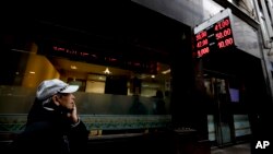 A man watches dollar rates outside an exchange house in Buenos Aires, Argentina, Aug. 30, 2018. Argentina's Central Bank increased its benchmark interest rate to 60 percent Thursday as the peso hit an all-time low. 