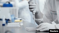 A researcher works in a lab run by Moderna Inc, in an undated still image from video.