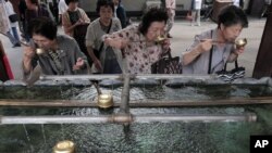 日本老年妇女在东京一处神社用圣水漱口。（2012年9月29日资料照）