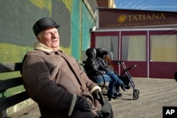 Yuriy Taras enjoys the sunshine while sitting on the Brighton Beach boardwalk in the Brooklyn borough of New York, Dec. 16, 2016.