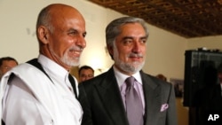 Afghan presidential candidates Ashraf Ghani and Abdullah Abdullah shake hands during a joint press conference in Kabul on July 12, 2014. 