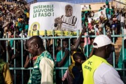 Supporters hold placards and cheer Burkina Faso's presidential candidate Zephirin Diabre during a rally in Ouagadougou on Nov. 15, 2020.