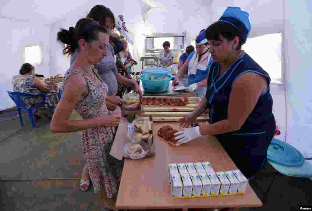 People receive food at a canteen of a refugee camp in Russia&#39;s Rostov region, Aug. 18, 2014.