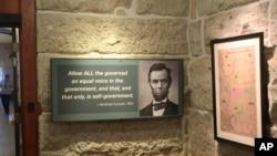 A historical exhibit at the Kansas Statehouse includes a display quoting President Abraham Lincoln next to a map showing the original extent of the Kansas-Nebraska territories before Kansas became a state and Lincoln took office in 1861. 