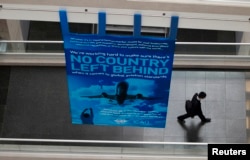 FILE - A delegate walks past a banner during a break at the International Civil Aviation Organization's (ICAO) global safety meeting in Montreal, Feb. 4, 2015.