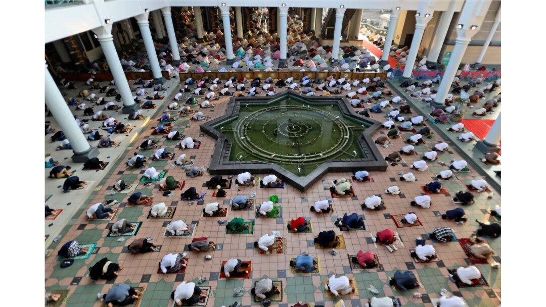 Muslims pray spaced apart to help curb the spread of coronavirus outbreak during an Eid al-Fitr prayer marking the end of Ramadan at Al Akbar mosque in Surabaya, East Java, Indonesia, May 13, 2021.