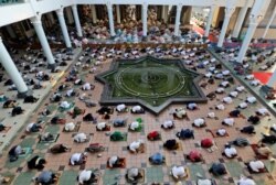 FILE - Muslims pray spaced apart to help curb the spread of coronavirus outbreak during an Eid al-Fitr prayer marking the end of Ramadan at Al Akbar mosque in Surabaya, East Java, Indonesia, May 13, 2021.