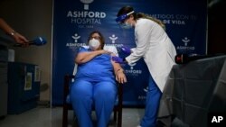 Epidemiologist Hilda Aleman reacts upon receiving the Pfizer-BioNTech COVID-19 vaccine, in San Juan, Puerto Rico, Dec. 15, 2020. 