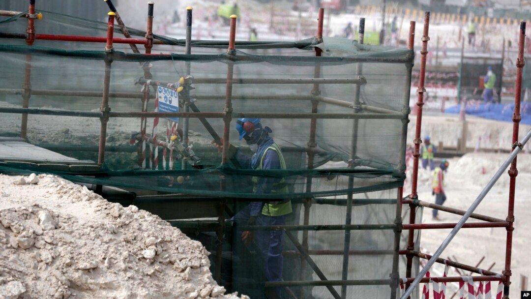 FILE - A foreign worker climbs scaffolding at the Al-Wakra Stadium that is under construction for the 2022 World Cup in Doha, Qatar, May 4, 2015.