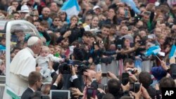 Pope Francis kisses a baby as he arrives for his weekly general audience in St. Peter's Square at the Vatican, Wednesday, Oct. 28, 2015.