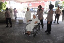 Seorang polisi wanita berjilbab mendorong seorang suster memasuki di sebuah gereja Katolik di Solo, Senin (23/12). (Foto: istimewa)