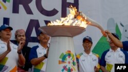 Penyalaan obor Asian Games 2018 dalam pawai obor di Jakarta, 15 Agustus 2018.
