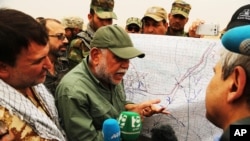 Hadi al-Amiri, leader of the Badr Brigades Shi'ite militia, explains a battle plan to his fighters near the front line on the outskirts of Fallujah in Anbar province, Iraq, June 1, 2015.