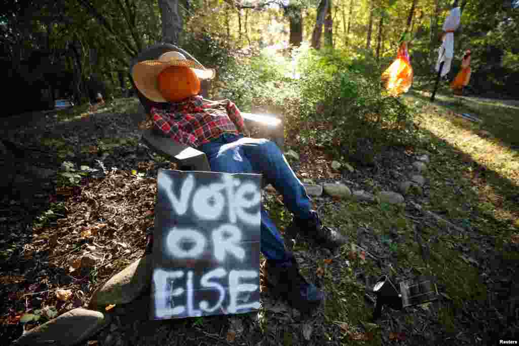 A hand-painted sign urging citizens to vote, sits with Halloween decorations in the front yard of a home in Chapel Hill, North Carolina, Oct. 20, 2024.