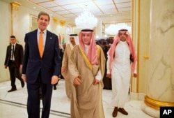 ລັດຖະມົນຕີການຕ່າງປະ​ເທດ ສະຫະລັດ ທ່ານ John Kerry ຢ່າງກັບ ລັດຖະມົນຕີ ການຕ່າງປະເທດ ຊາອຸດີ ທ່ານ Adel al-Jubeir, ກາງ.