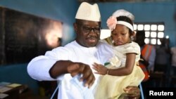 Julius Maada Bio, en tête de la présidentielle en train de voter avec sa fille, Freetown, le 7 mars 2018.