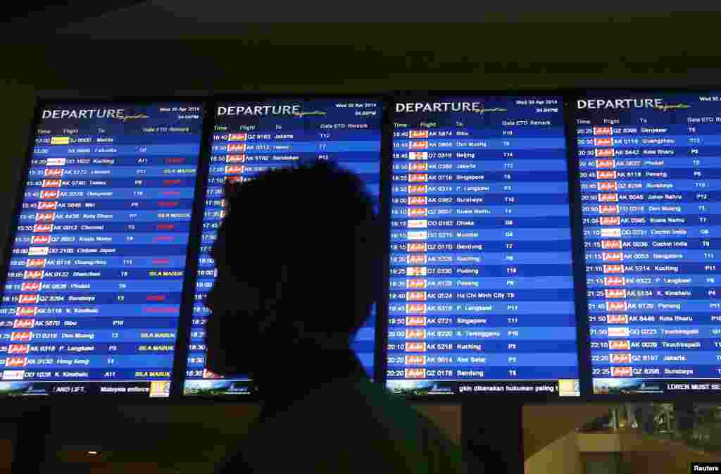 A man walks in front of a flight board at Kuala Lumpur International Airport 2 (KLIA2) in Sepang, Apr. 30, 2014. 