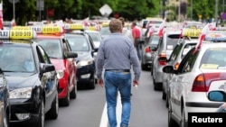 FILE - Taxi drivers protest against unlicensed carriers and competition from private shared ride businesses like Uber in Poznan, Poland, June 5, 2017.