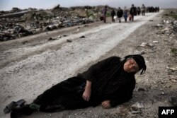 Seorang wanita Irak terbaring di tanah ketika warga sipil melarikan diri dari Mosul sementara pasukan Irak masuk ke dalam kota selama pertempuran melawan ISIS pada 8 Maret 2017. (Foto: AFP)