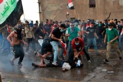 An injured protester is being attended to during a demonstration in central Baghdad, Iraq, Oct. 25, 2019.