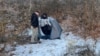 A police officer stands next to Kai Zhuang at the site where he was found in the mountains near Brigham City, Utah, on Dec. 31, 2023, after being reported missing in an apparent cyber kidnapping scheme. (Riverdale Police Department via AFP)