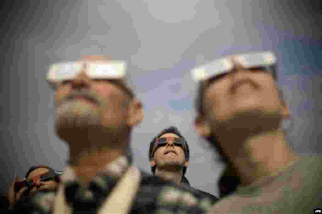 Israelis watch at a partial solar eclipse in the town of Givatayim near Tel Aviv, Israel, Tuesday, Jan. 4, 2011. A partial solar eclipse began Tuesday in the skies over the Mideast and will extend across much of Europe. (AP Photo/Ariel Schalit)