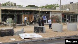 A man cleans his shop after a suicide car bomber blew himself up at a checkpoint in Dafniya outside Misrata, Libya, May 31, 2015.