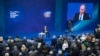 FILE - Russian President Vladimir Putin, sitting on the stage at center rear, speaks to his supporters during a meeting for his campaign in Moscow, Jan. 30, 2018. 