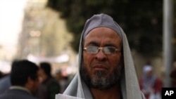 A member of the Muslim Brotherhood organization hold the cover of a local paper depicting former Egyptian President Hosni Mubarak and which reads in Arabic, "He Finally Stepped Down" in Cairo's Tahrir square, Feb 12, 2011