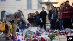 Warga memberi penghormatan kepada para korban serangan teror maut di Paris di depan Kedutaan Besar Perancis di Roma (16/11). (AP/Andrew Medichini)
