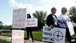 Demonstrators gather outside the dental practice of Walter Palmer, who returned to work, Sept. 8, 2015, in Bloomington, Minnesota.