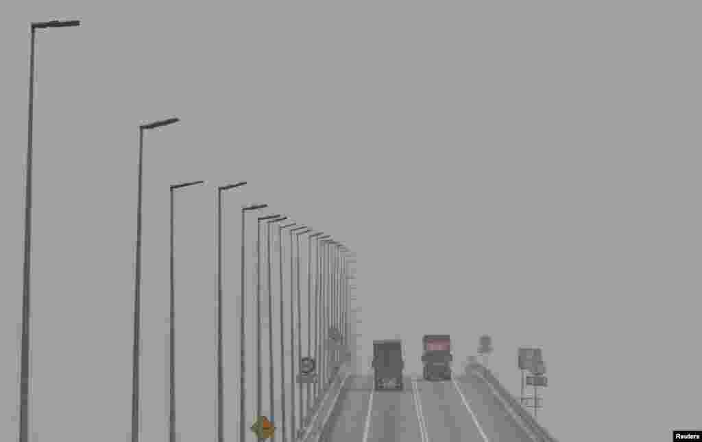 Trucks cross a bridge shrouded in haze in Klang, Malaysia. The thick so-called "haze," caused by slash-and-burn clearances on the islands of Sumatra and Borneo, has pushed air quality to unhealthy levels in Malaysia and neighboring Singapore.