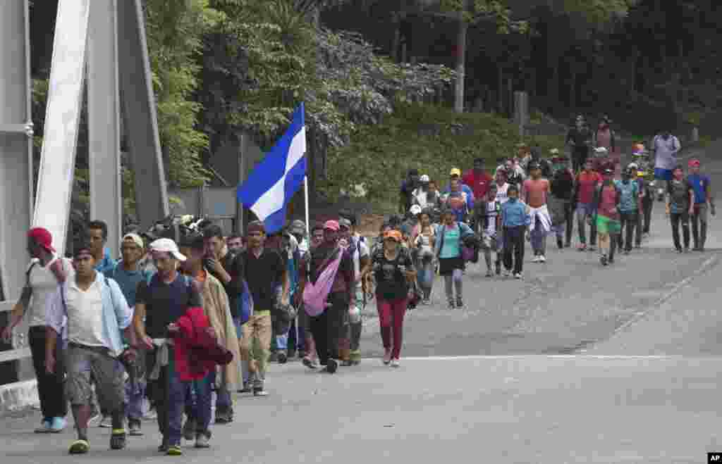 Honduran migrants walk toward the United States as they make their way through Chiquimula, Guatemala. President Donald Trump threatened to cut aid to Honduras if the country does not stop the caravan of migrants.