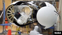 An Orbital Sciences technician completes final checks of NASA's Nuclear Spectroscopic Telescope Array, or NuSTAR