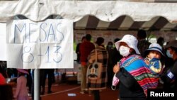 Una mujer con un niño acude a votar en las elecciones regionales de Bolivia el 7 de marzo de 2021.