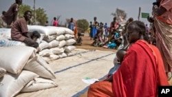 FILE - People wait to receive food at a World Vision food distribution site in Malualkuel in the Northern Bahr el Ghazal region of South Sudan, April 5, 2017. 