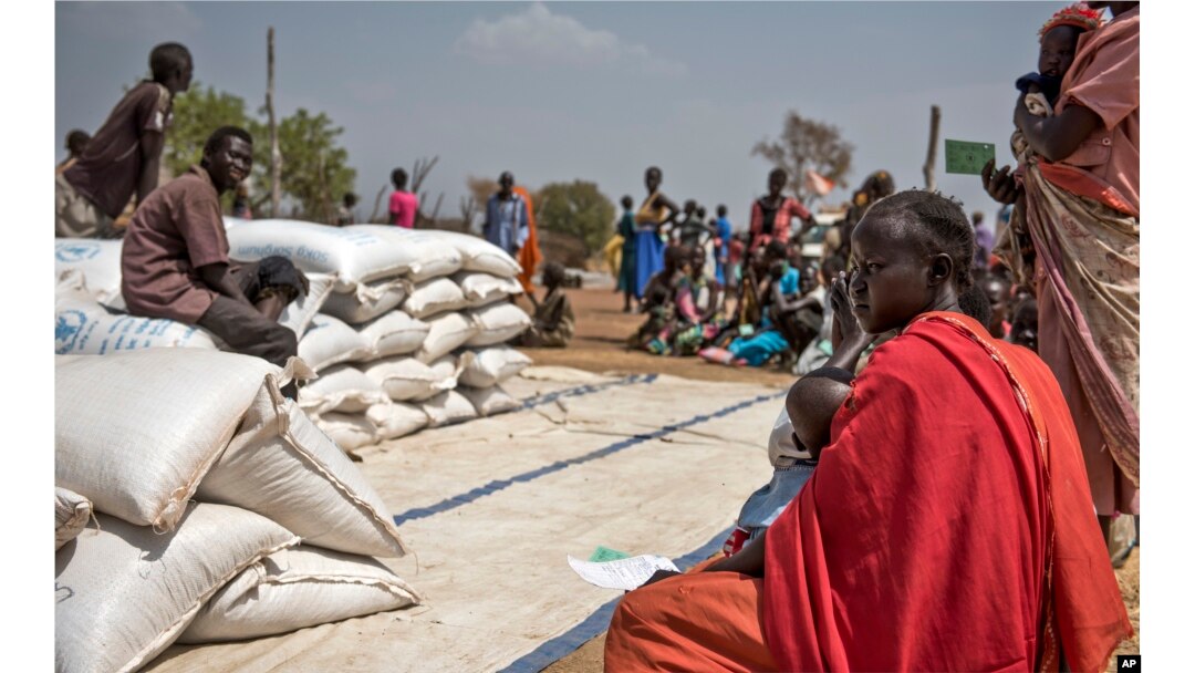 People wait to receive food at a World Vision food distribution site in Malualkuel in the Northern Bahr el Ghazal region of South Sudan, April 5, 2017.