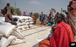 People wait to receive food at a World Vision food distribution site in Malualkuel in the Northern Bahr el Ghazal region of South Sudan, April 5, 2017.