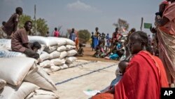 FILE - People wait to receive food at a World Vision food distribution site in Malualkuel in the Northern Bahr el Ghazal region of South Sudan, April 5, 2017. 